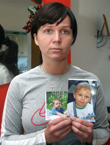 Baiba holding her missing children's photos